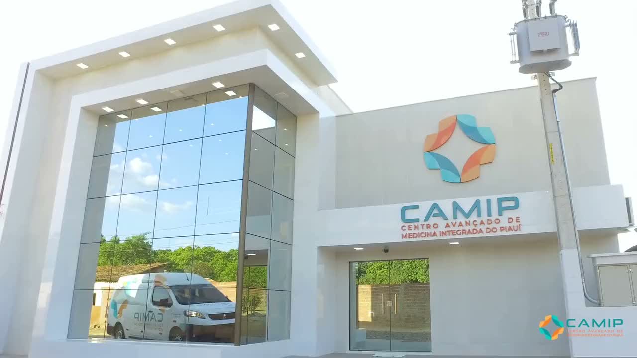 Fachada da unidade do CAMIP em Rio Grande do Piauí, com o símbolo e o letreiro da clínica sobre a entrada de vidro.