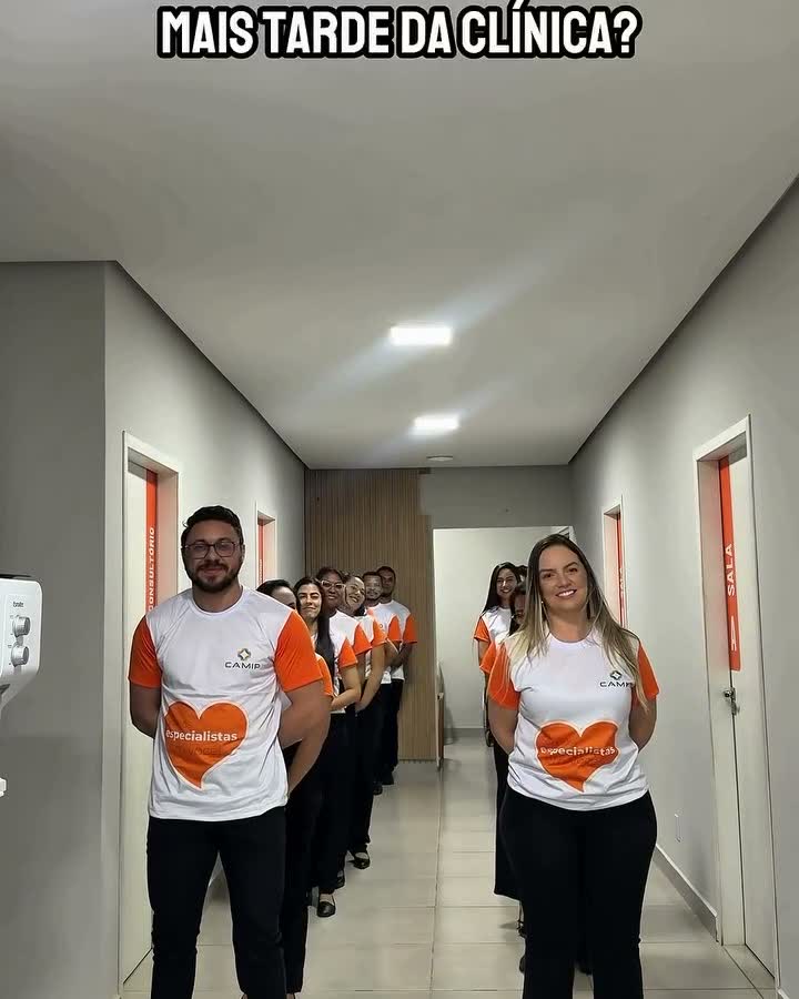 Equipe da clínica reunida no corredor entre os consultórios.